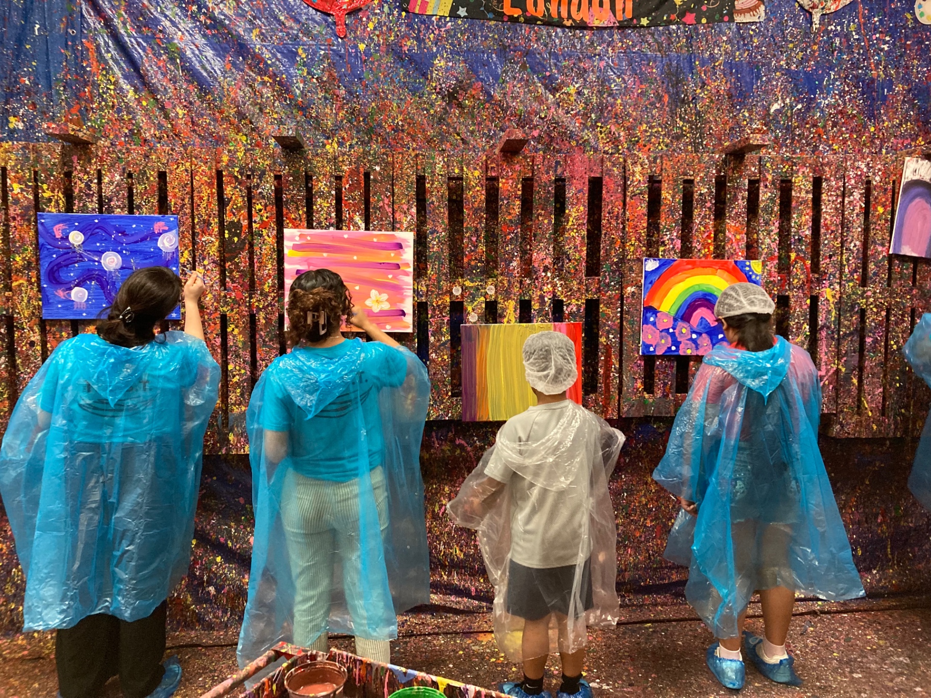 Painters at work along the splatter wall